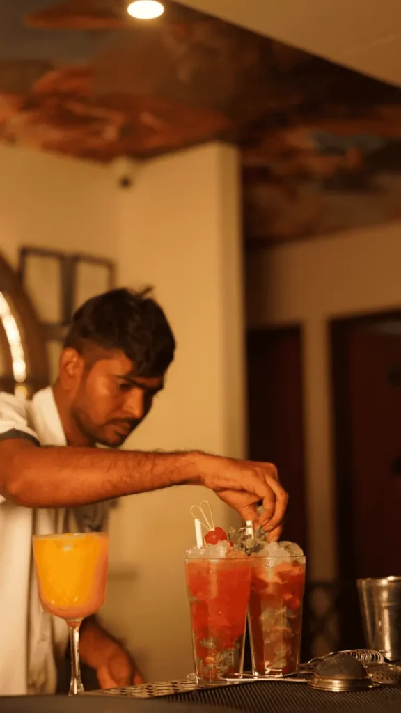 Bartender crafting fresh cocktails behind the bar at Candles Brewhouse.